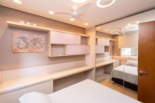 een kleine slaapkamer met een bed en een spiegel bij Modernos Flats no Setor Bueno TXP03 in Goiânia