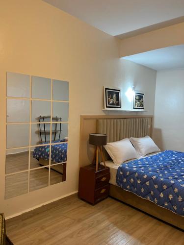 - une chambre avec un lit et un miroir dans l'établissement Appartement au centre ville de fès, à Fès