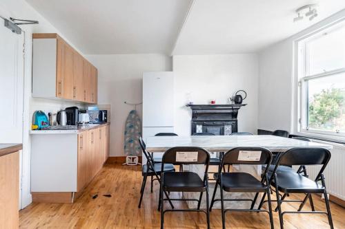 uma cozinha com mesa e cadeiras num quarto em Lady Road Apartment em Edimburgo