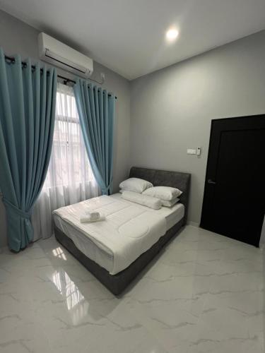 - une chambre avec un lit et une fenêtre avec des rideaux bleus dans l'établissement THE 99 SUITES, à Kuala Terengganu