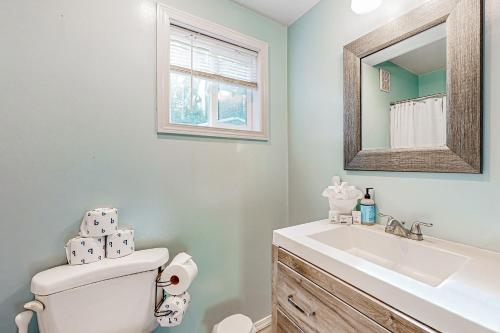 a bathroom with a sink and a toilet and a mirror at Alder Creek A-Frame in Sandy