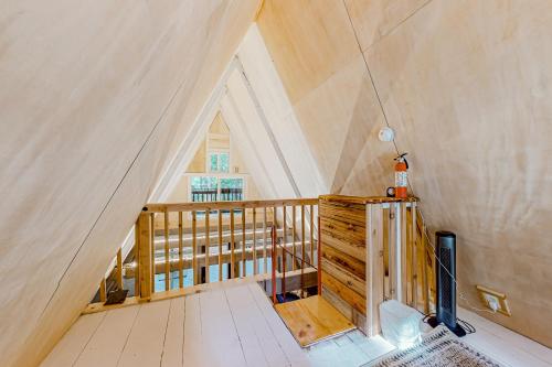 Camera mansardata con scala in legno e soffitto. di Alder Creek A-Frame a Sandy