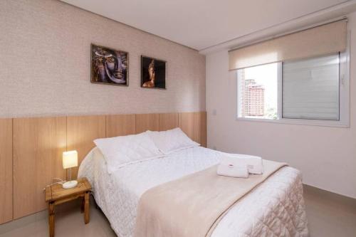 - une chambre avec un lit blanc et une fenêtre dans l'établissement Lindos Flats no Setor Bueno TXP02, à Goiânia