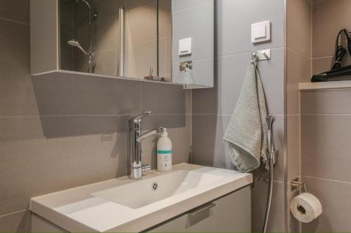 a bathroom with a sink and a mirror at Pramea Apartments Marina in Kuopio