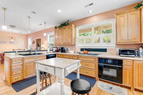 a large kitchen with wooden cabinets and a white island at Seabreeze Serenity in Wilmington