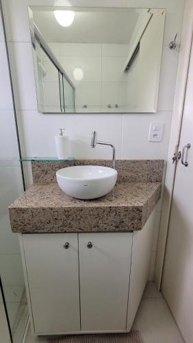 y baño con lavabo blanco y espejo. en Loft / Studio Privativo com Estacionamento, en Florianópolis