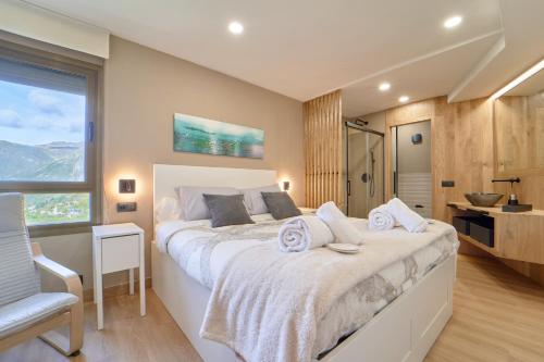 um quarto com uma cama grande e uma casa de banho em Apartamento Baqueira pie pistas cota 1500 em Baqueira-Beret