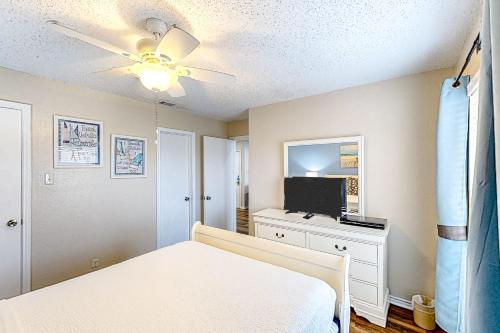 a bedroom with a bed and a flat screen tv at The Beach Club #363 in Padre Island