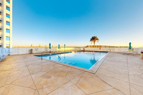 a swimming pool on a patio with a building at Regency Towers W 101 in Pensacola Beach