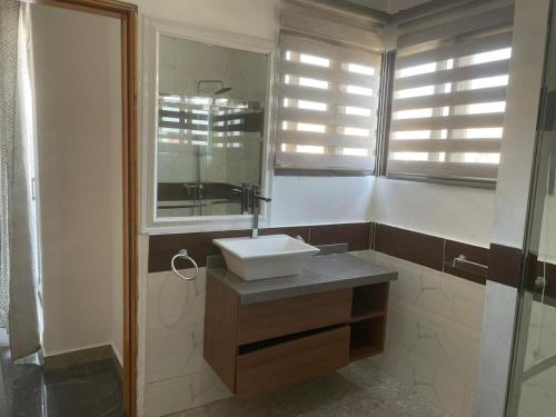 ein Bad mit einem Waschbecken und einem Spiegel in der Unterkunft 4-bedroom City view Town House Accra in Accra