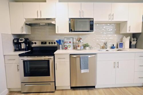 a kitchen with white cabinets and stainless steel appliances at Central 5 Bedroom, AC, Rogers, Commonwealth, EXPO in Edmonton