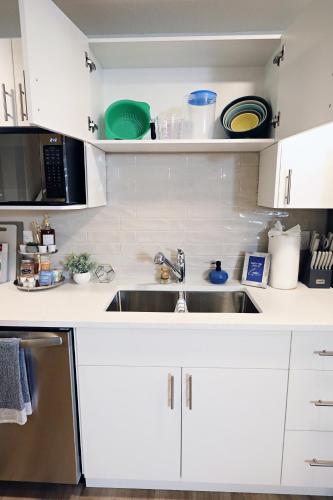 a kitchen with white cabinets and a sink at Central 5 Bedroom, AC, Rogers, Commonwealth, EXPO in Edmonton