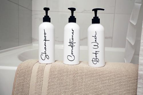 three bottles sitting on a table in a bathroom at Central 5 Bedroom, AC, Rogers, Commonwealth, EXPO in Edmonton