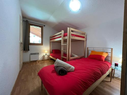 een slaapkamer met 2 stapelbedden met rode lakens bij Montagne Duplex-Orelle 9 pers. avec SPA in Orelle