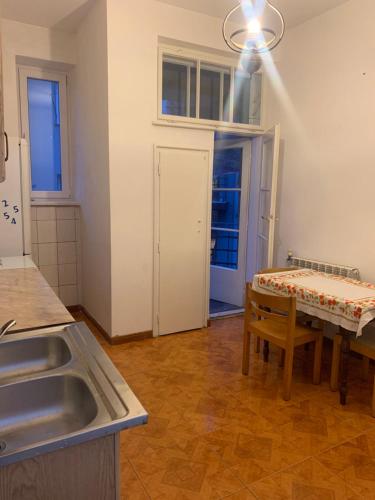 a kitchen with a sink and a table at Central Apartament Dworskiego in Przemyśl