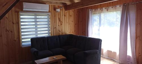 a living room with a couch and a window at Cabañas Caiquen La Junta in La Junta