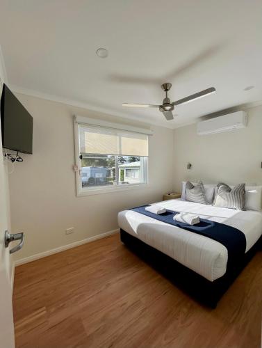 a bedroom with a large bed and a window at Shelly Beach Holiday Park in The Entrance