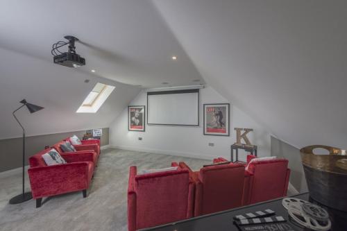 a living room with red chairs and a white wall at The Heyford Hotel in Upper Heyford