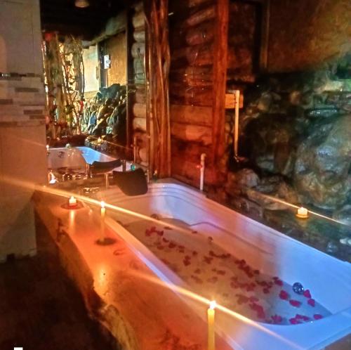 a bath tub filled with lots of candles in a room at Cabaña en el Arbol Picasso in Bogotá