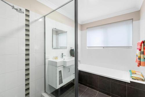 a bathroom with a shower and a sink at Denhams Beach Waterfront in Surf Beach