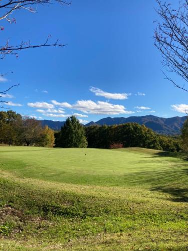 a green field with trees and mountains in the background at ALBERGO DEL PESCATORE in Minamiaizu