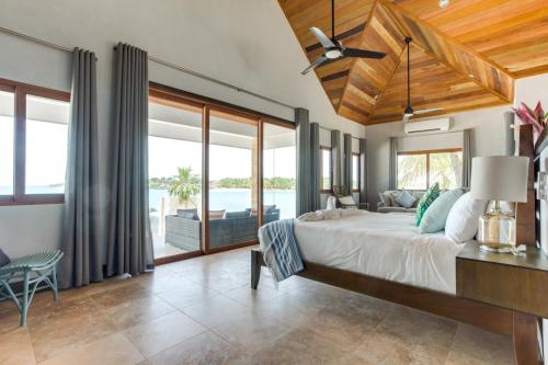 - une chambre avec un grand lit et une vue sur l'océan dans l'établissement The Enclave - Your Own Private Island Retreat, à Placencia