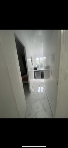 una habitación blanca vacía con una escalera que conduce a una habitación en Appartement beau, en Drancy