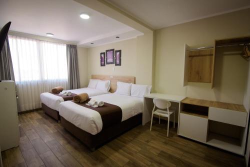 a hotel room with a large bed and a desk at Hotel VILLA LUNA in Moquegua
