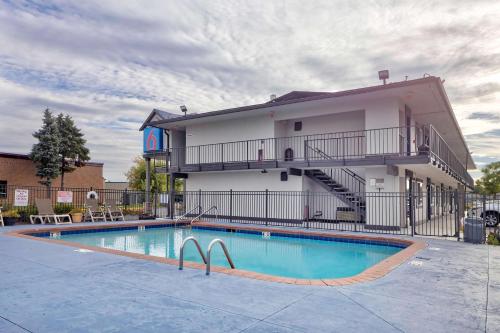 a hotel with a swimming pool in front of a building at Motel 6-Oshkosh, WI in Oshkosh