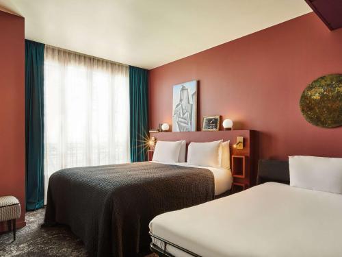 a hotel room with two beds and a window at Mercure Paris Tour Eiffel Pont Mirabeau in Paris