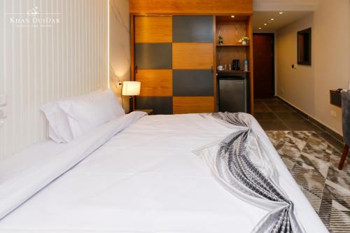 a large white bed in a room with a kitchen at Khan Duidar Inn - Pyramids View Rooftop in Cairo