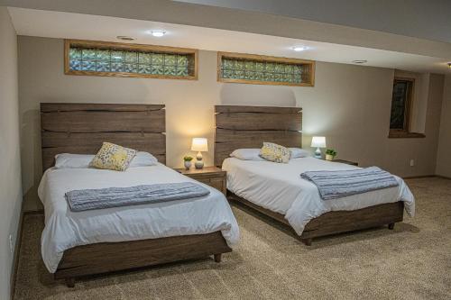 um quarto com 2 camas e 2 janelas em Spacious Vacation Home em Chanhassen