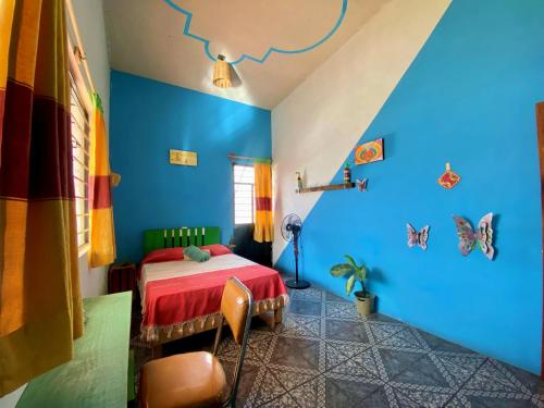 een slaapkamer met blauwe muren en een bed met een rode sprei bij Casa EL Mundo in Oaxaca City