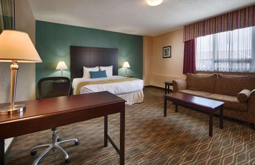 a hotel room with a bed and a couch at Best Western Plus Durham Hotel & Conference Centre in Oshawa