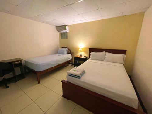 sypialnia z 2 łóżkami i biurkiem z lampką w obiekcie Villa Garza Inn w mieście Guayaquil