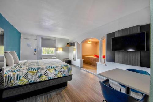 um quarto de hotel com uma cama e uma secretária e um quarto em Studio 6 Jackson MS I 55 em Jackson