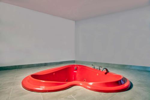 eine große rote Badewanne in einem Zimmer in der Unterkunft Studio 6 Jackson MS I 55 in Jackson