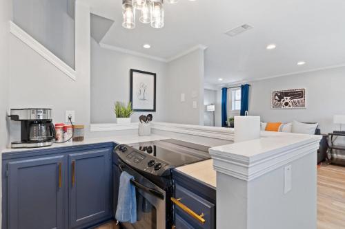 a kitchen with blue cabinets and a stove top oven at Quiet Retreat Off Magazine W Balcony & Parking! in New Orleans