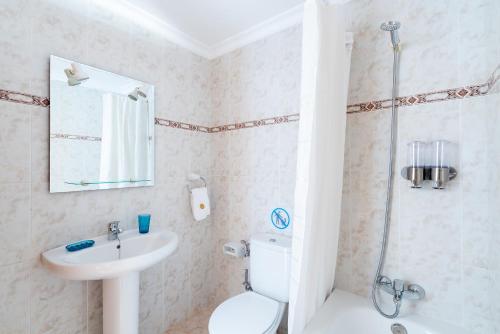 Un baño con inodoro, lavabo y ducha. en Delmar Natur - Gallo, en Charco del Palo