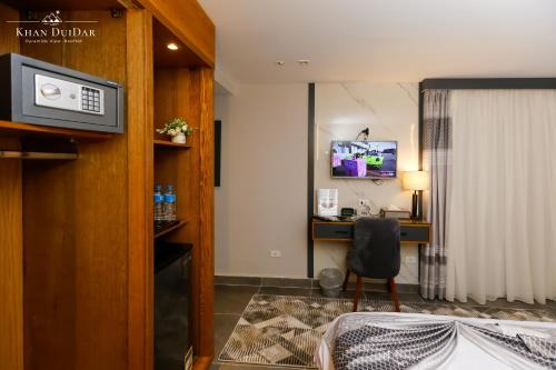 a hotel room with a bed and a desk and a television at Khan Duidar Inn - Pyramids View Rooftop in Cairo