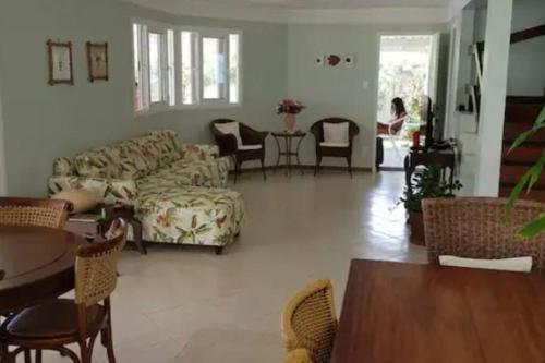 ein Wohnzimmer mit einem Sofa und einem Tisch in der Unterkunft Pé na areia, casa beira-mar, Guarajuba in Guarajuba