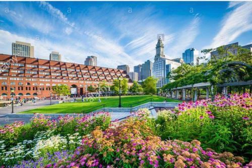 a park with flowers in front of a building at Boston Harbor views Modern north end condo FREE PARKING! in Boston