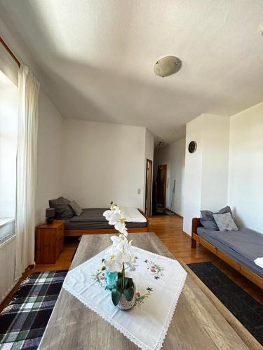a room with two beds and a table with flowers on it at Wunderschönes Appartement Nahe der Berge in Bruckmühl