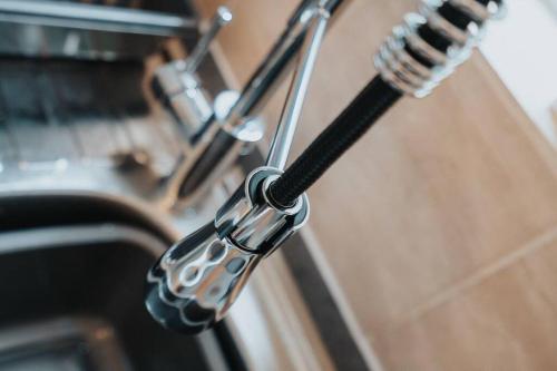 a close up of a chrome kitchenaucet at Charming 3BD Home Didsbury House in Manchester