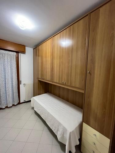 een slaapkamer met een bed en houten kasten bij Vicino al centro in Novara