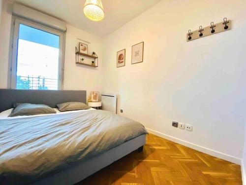 une chambre avec un lit et une grande fenêtre dans l'établissement Lumineux T1 : balcon, TV sat&VOD, proche Part-Dieu & Université, à Villeurbanne