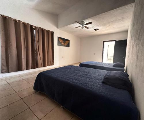 a bedroom with two beds and a ceiling fan at Los toronjos in Tequila