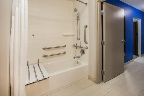 a bathroom with a bath tub with a shower curtain at Holiday Inn Express & Suites Hayward, an IHG Hotel in Hayward