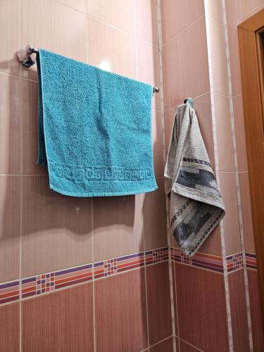 a bathroom with blue towels hanging on a wall at Квартира в Алматы . 23 in Almaty