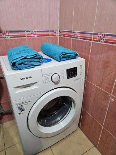a washing machine with blue towels on top of it at Чистая и уютная квартира не дорого in Almaty